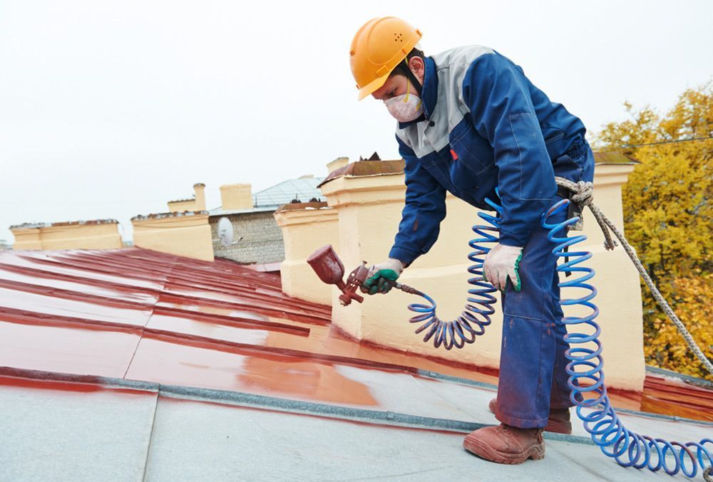 Man using spray brush to paint the roof — Painters in Fraser Coast, QLD