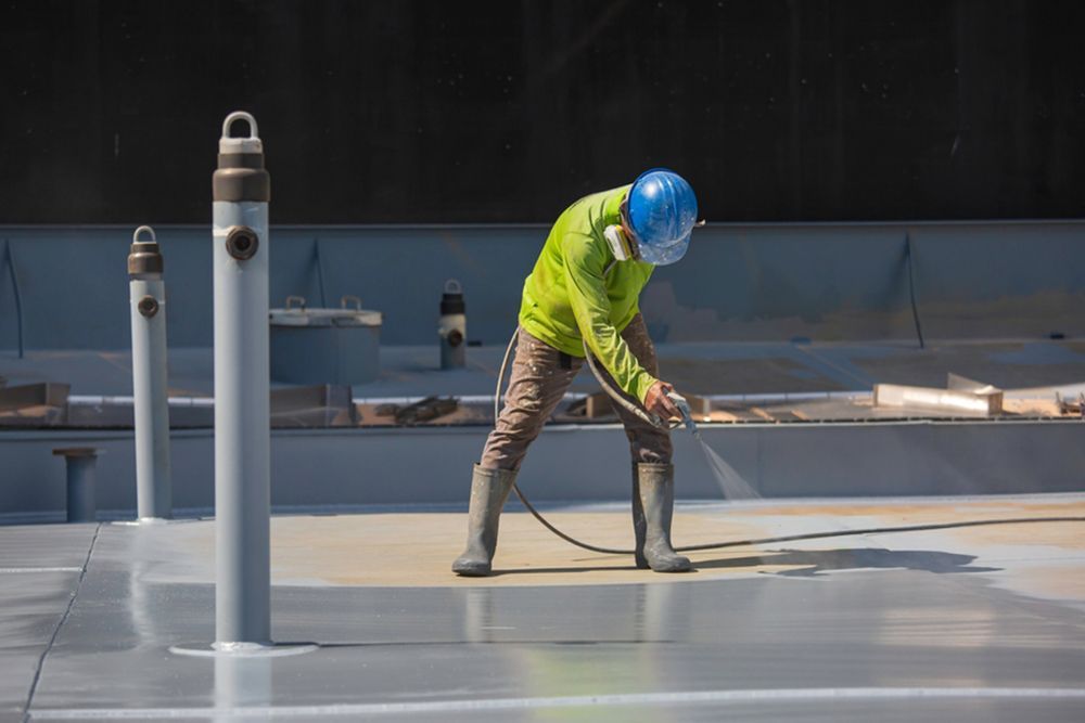 Painter using sprayer to paint the floor — Interior Painting in Maryborough, QLD