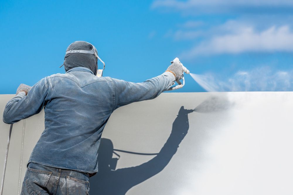 Painter using spray gun to paint the walls — Interior Painting in Hervey Bay, QLD