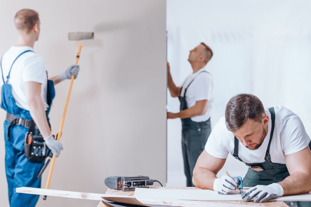 Three professional painters paint the interior of a house — Interior Painting Near Me in Fraser Coast, QLD