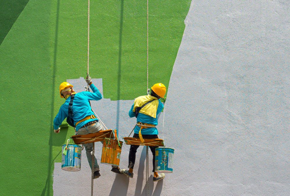 Two people painting a wall while suspended from roped — Painters in Fraser Coast, QLD