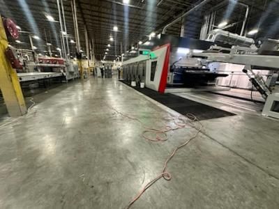 Large industrial printing press inside a factory.