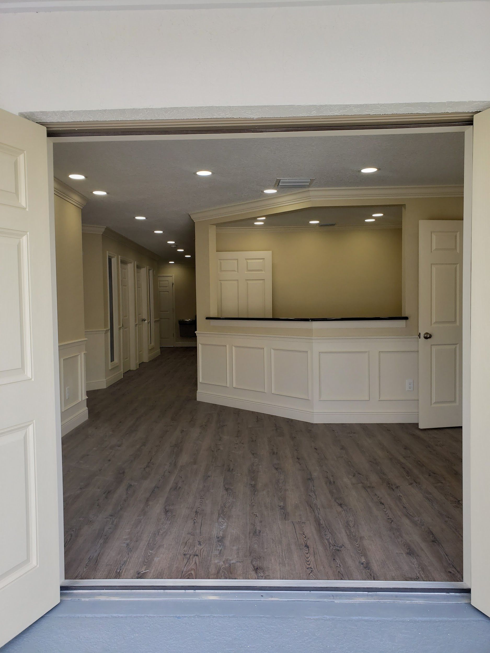 A hallway with a reception desk in the middle of it