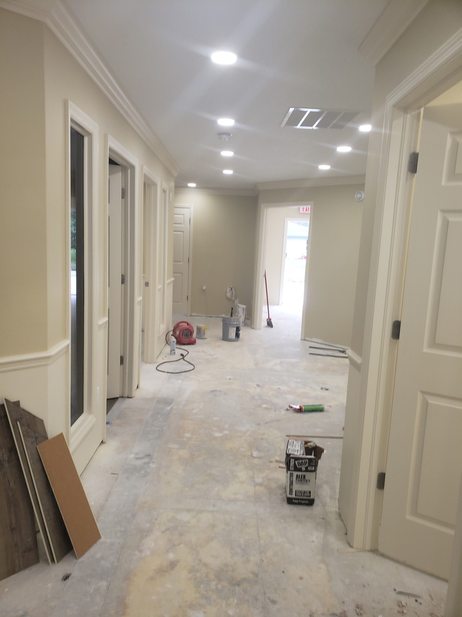An empty hallway with a bucket of paint on the floor.