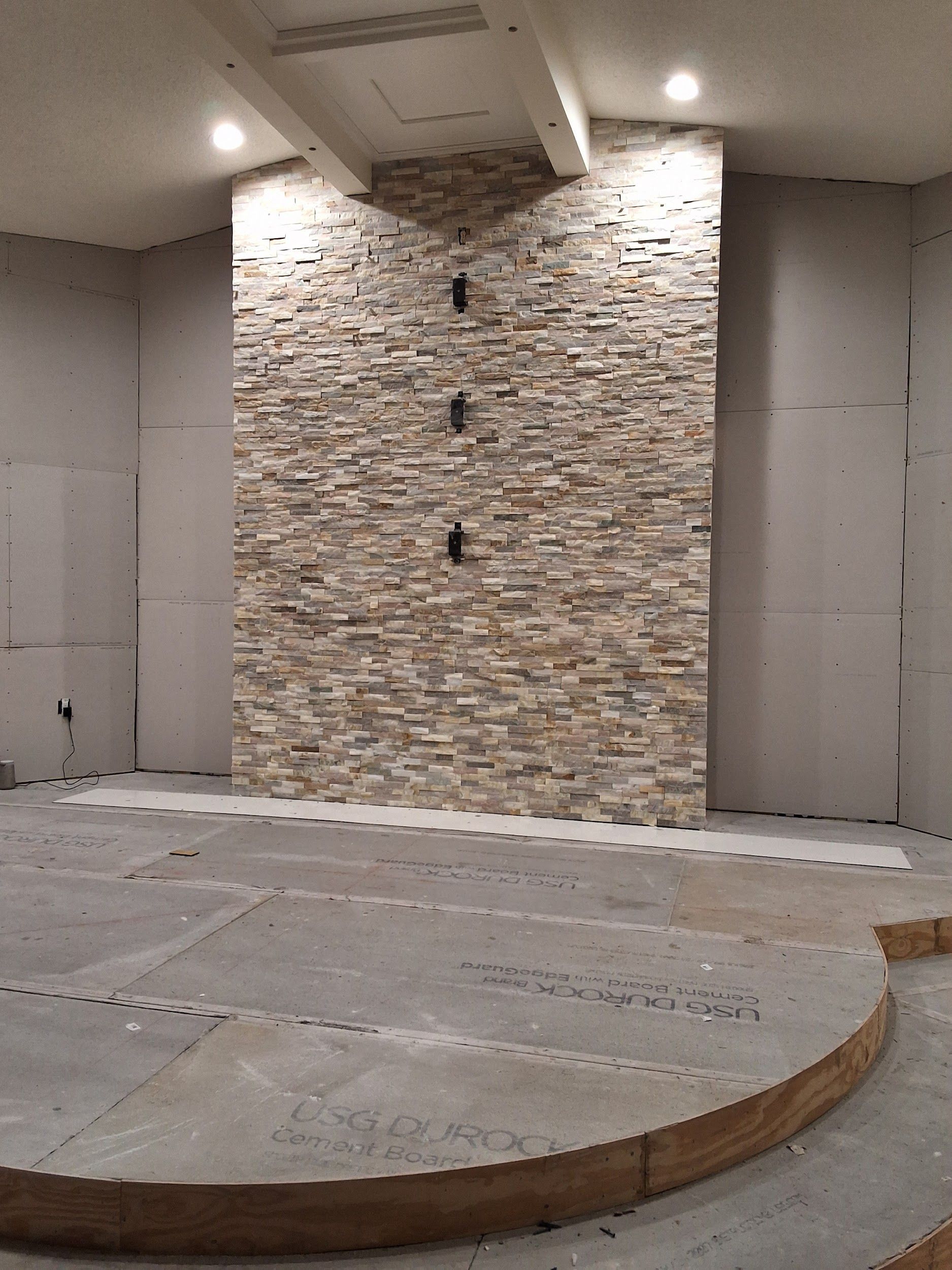 A room with a stone wall and a wooden platform