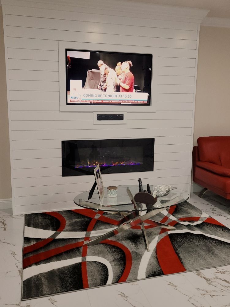 A living room with a fireplace and a flat screen tv