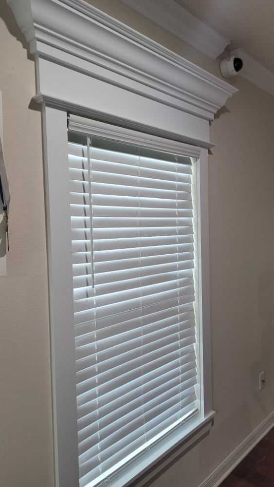 A window with blinds on it in a room.