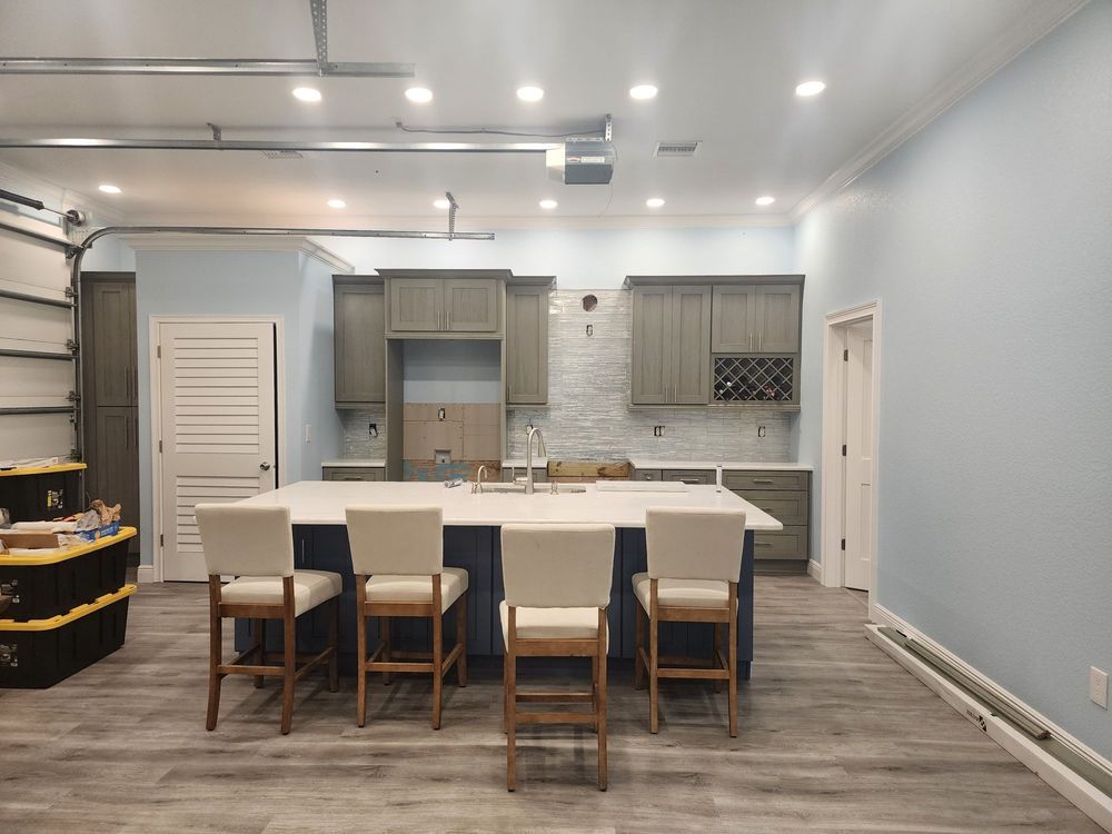 A kitchen with a large island and chairs in a garage.