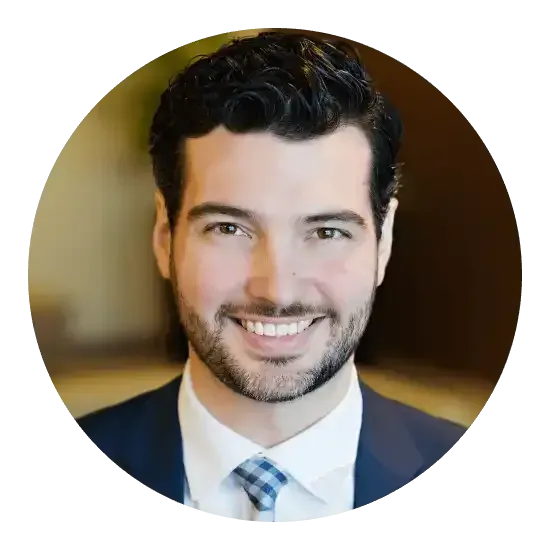 Homme en costume, souriant et portant une cravate.