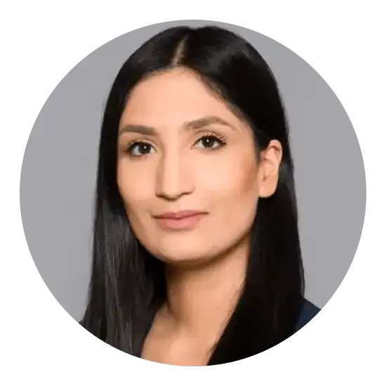 Femme aux cheveux foncés regardant le spectateur sur fond gris.