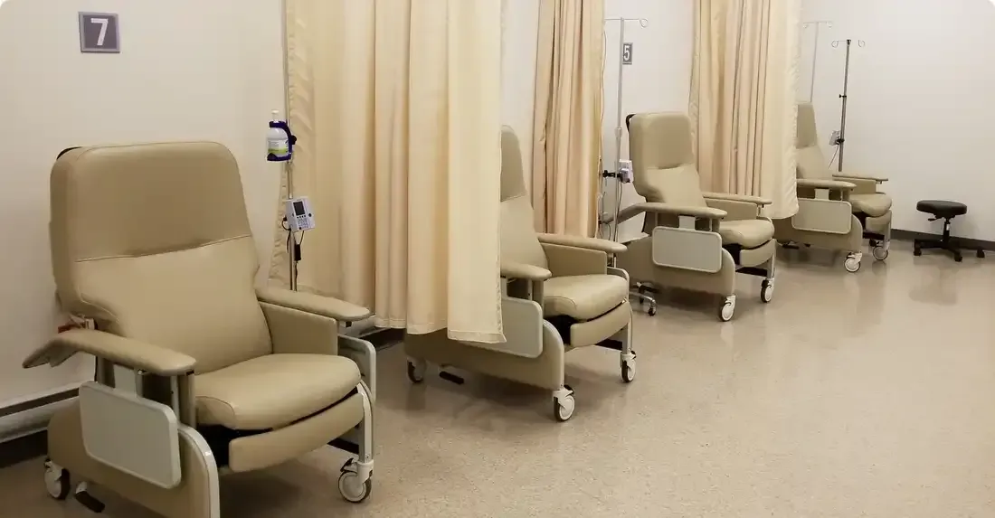 Salle d'attente avec chaises beiges, rideaux d'intimité et matériel médical.