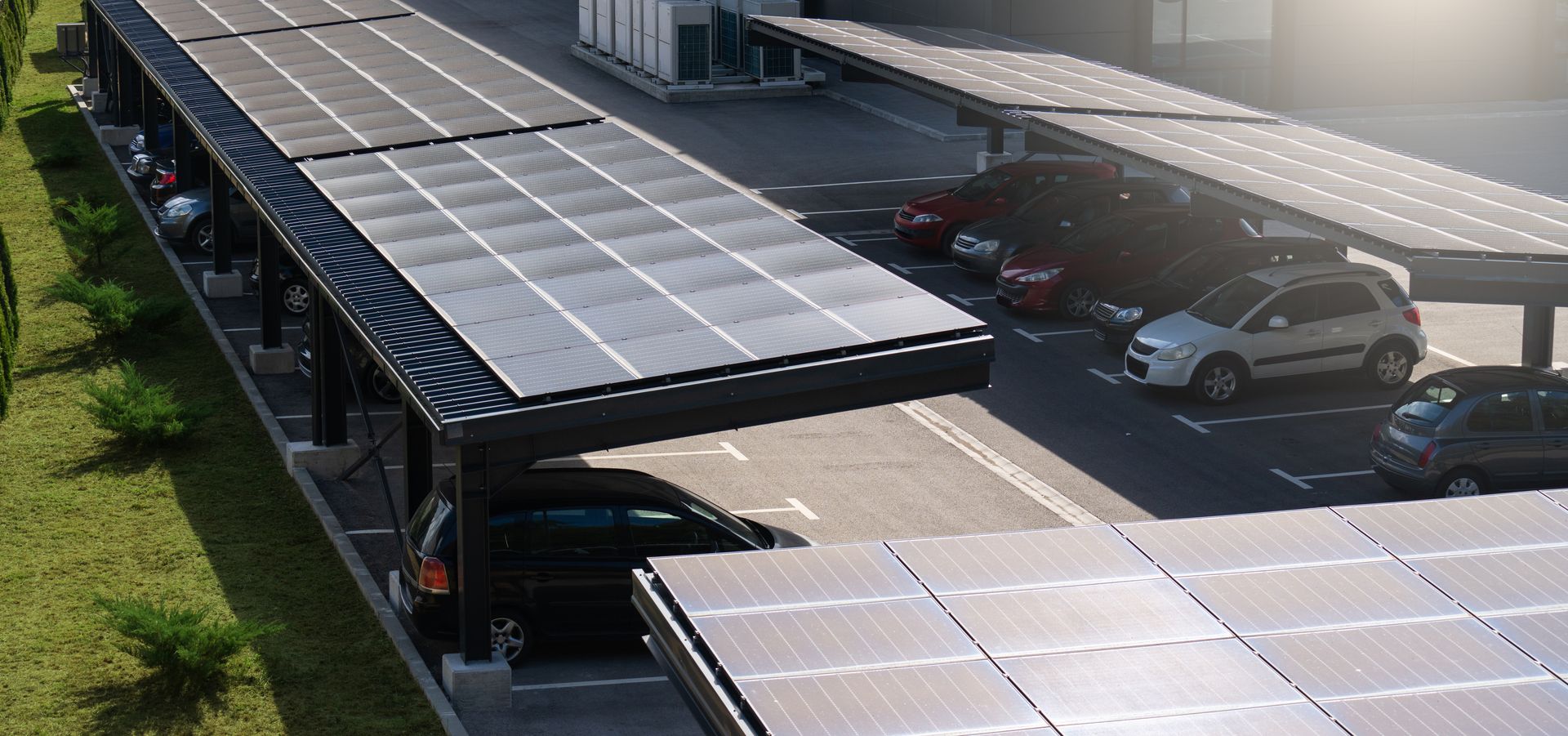 An aerial view of a parking lot with solar panels on the roof.