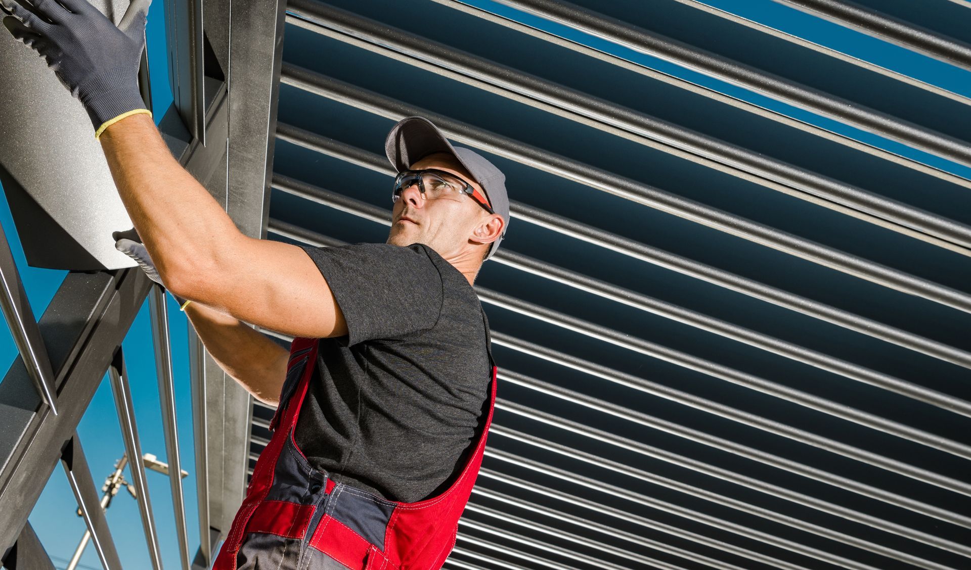 A man is standing on a ladder working on a metal structure.