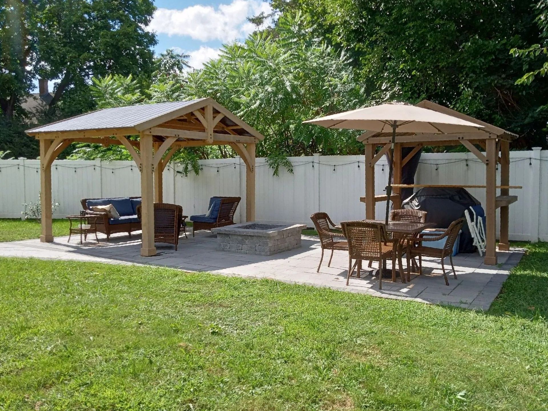 A backyard with a gazebo and a fire pit