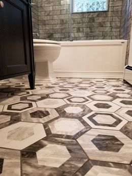 A bathroom with a hexagon tile floor and a bathtub.