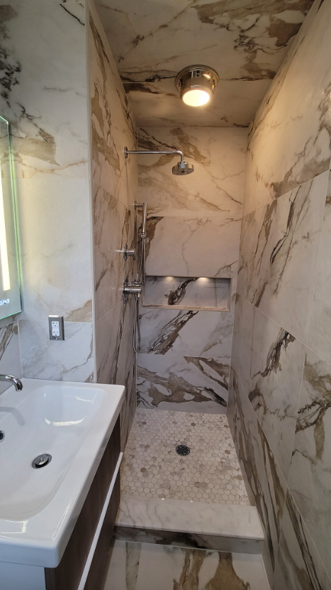 A bathroom with a sink and a walk in shower.