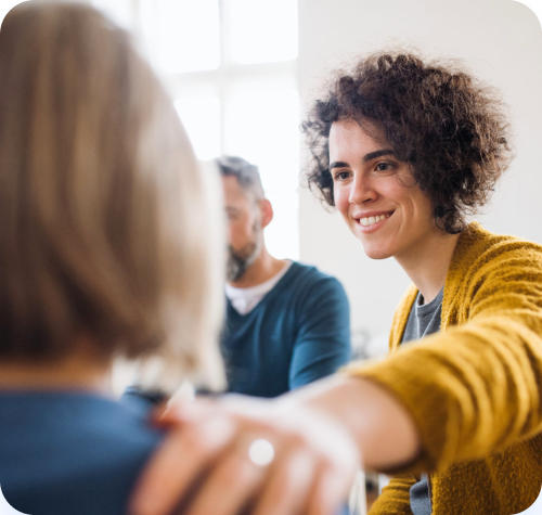 Un groupe de personnes sont assises autour d'une table et discutent entre elles.