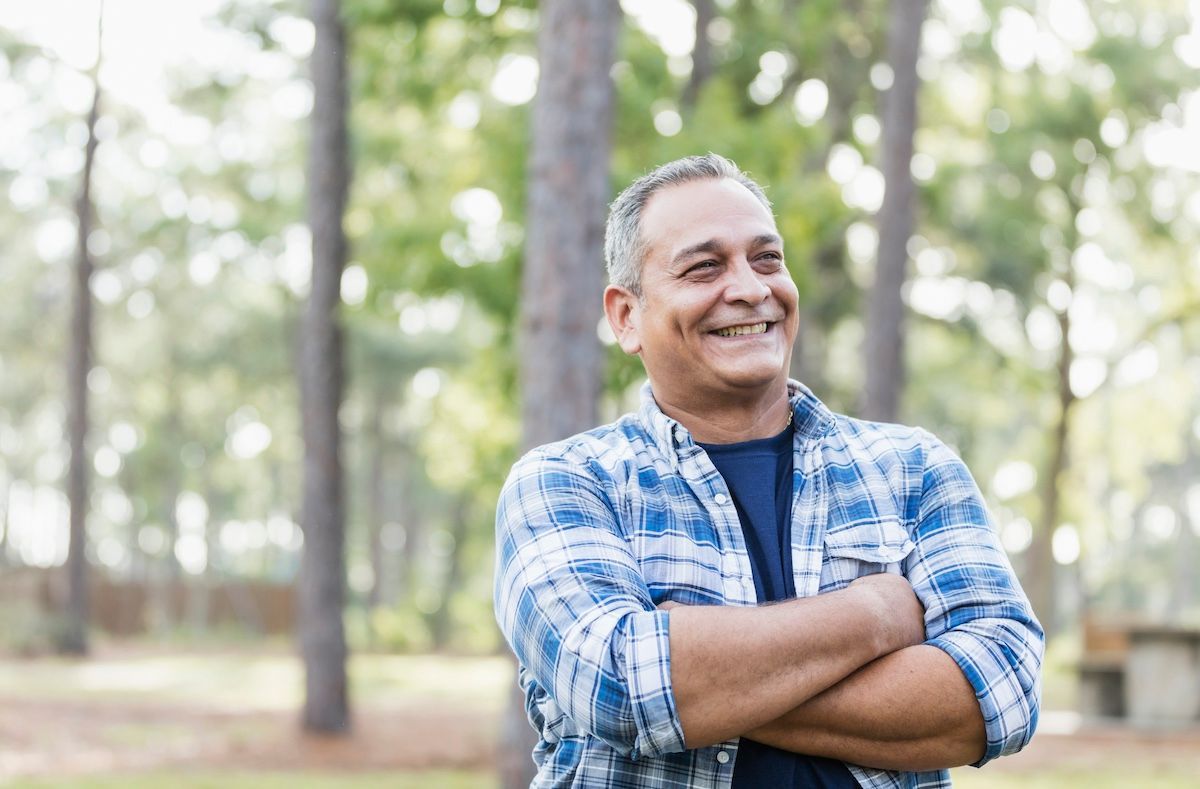 Un homme souriant debout en plein air