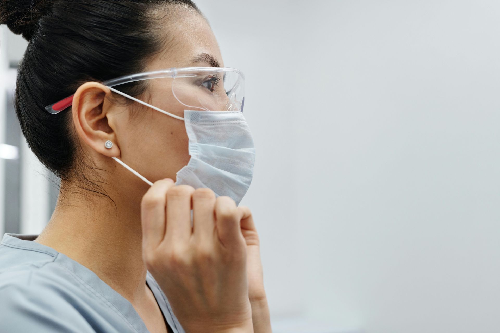 A woman wearing a surgical mask and glasses