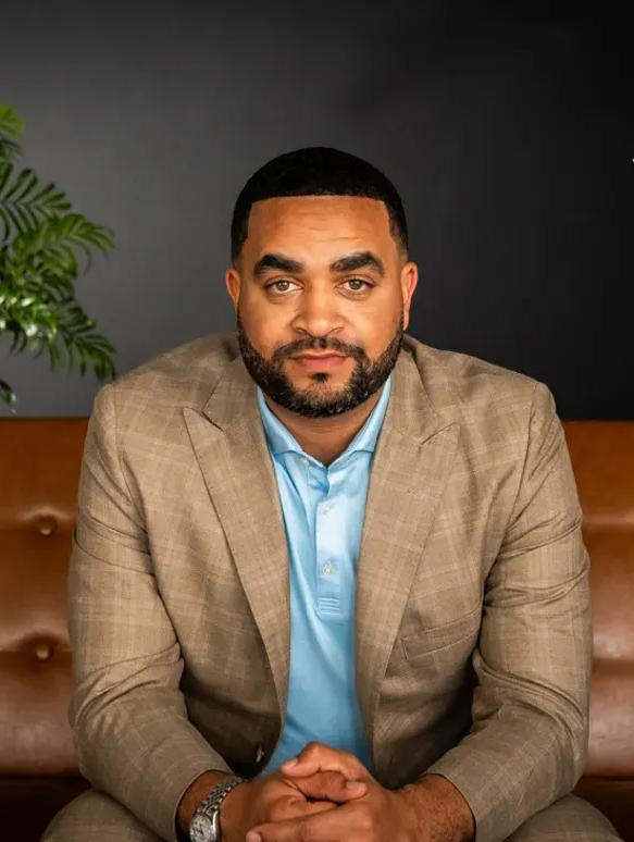 A man in a striped shirt is smiling for the camera.
