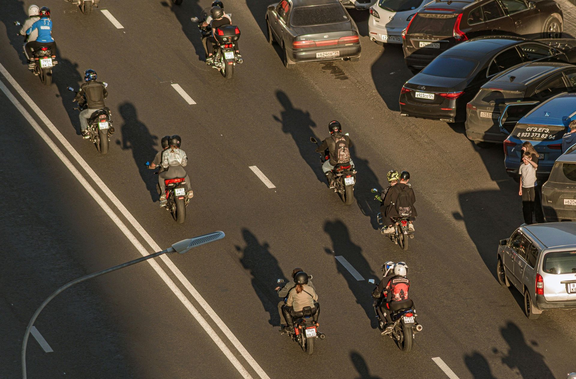 Man with glasses, writing at desk near a window. A small wind turbine model and a cup of coffee are on the table.