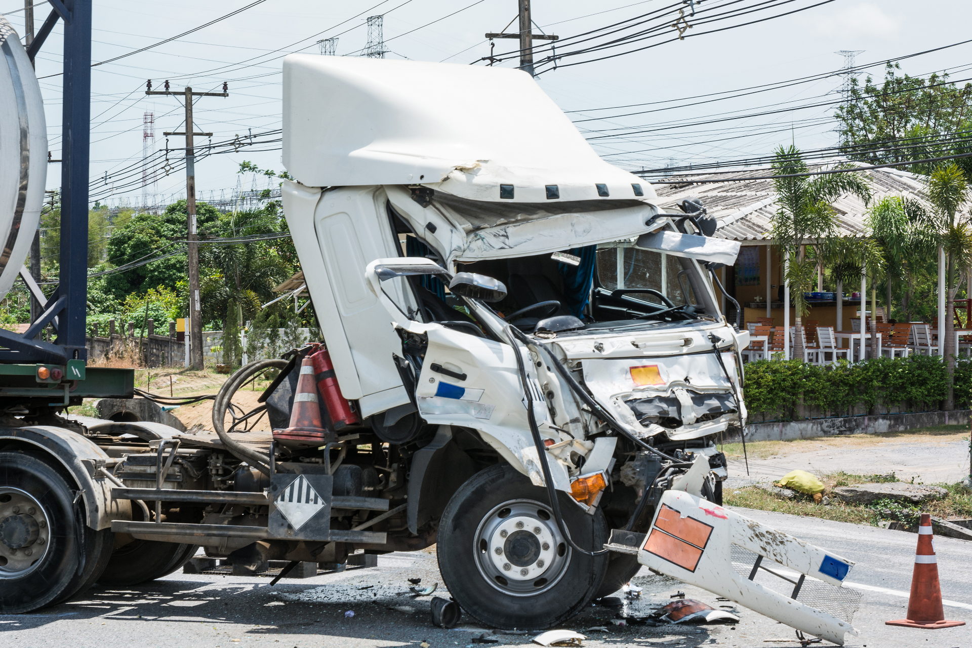 Man with glasses, writing at desk near a window. A small wind turbine model and a cup of coffee are on the table.