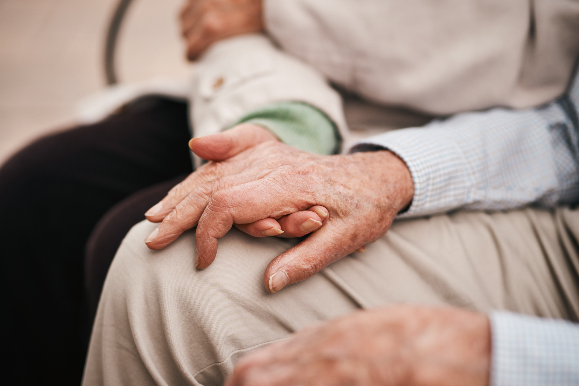 Man with glasses, writing at desk near a window. A small wind turbine model and a cup of coffee are on the table.