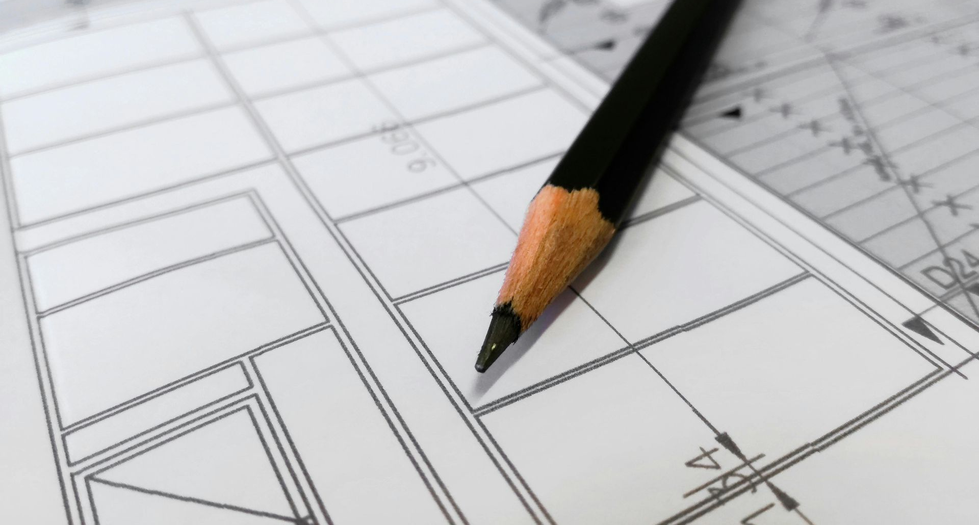 Blueprint with a black pencil resting on it, likely for an architectural or engineering project.