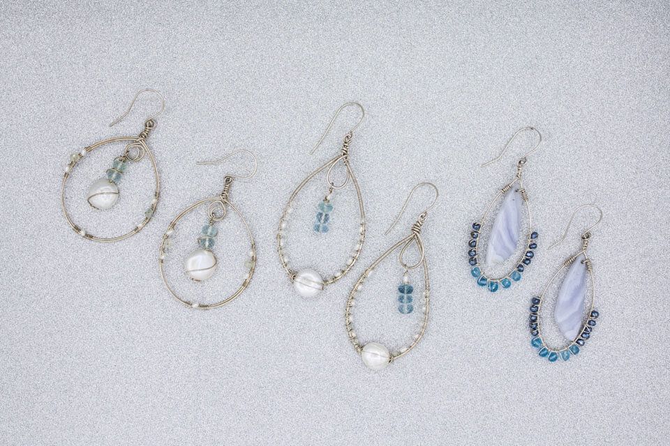 A group of earrings are sitting on a white surface.