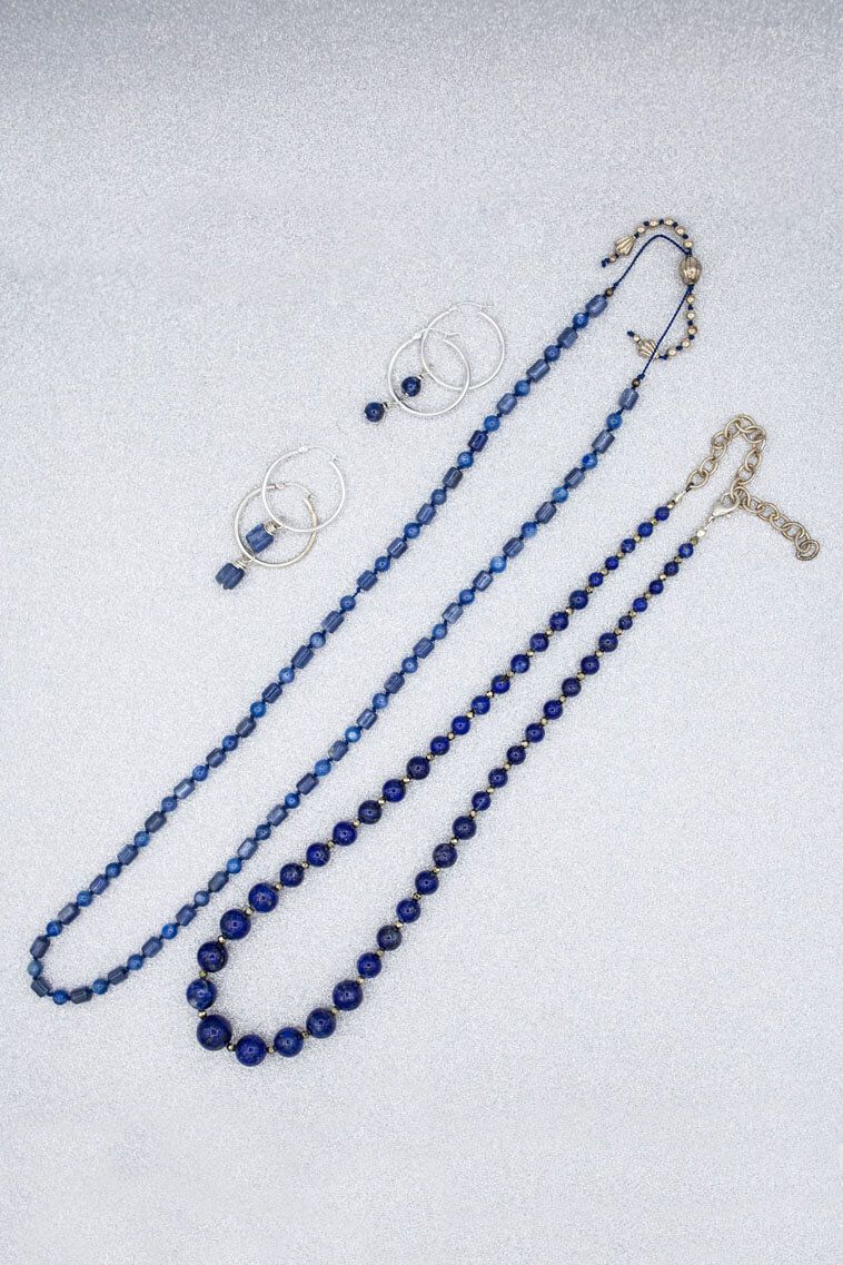 A necklace and earrings are on a white surface