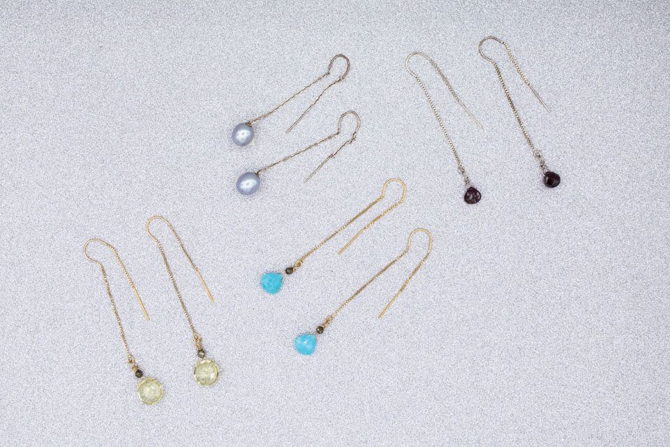 A group of earrings are sitting on a white surface.