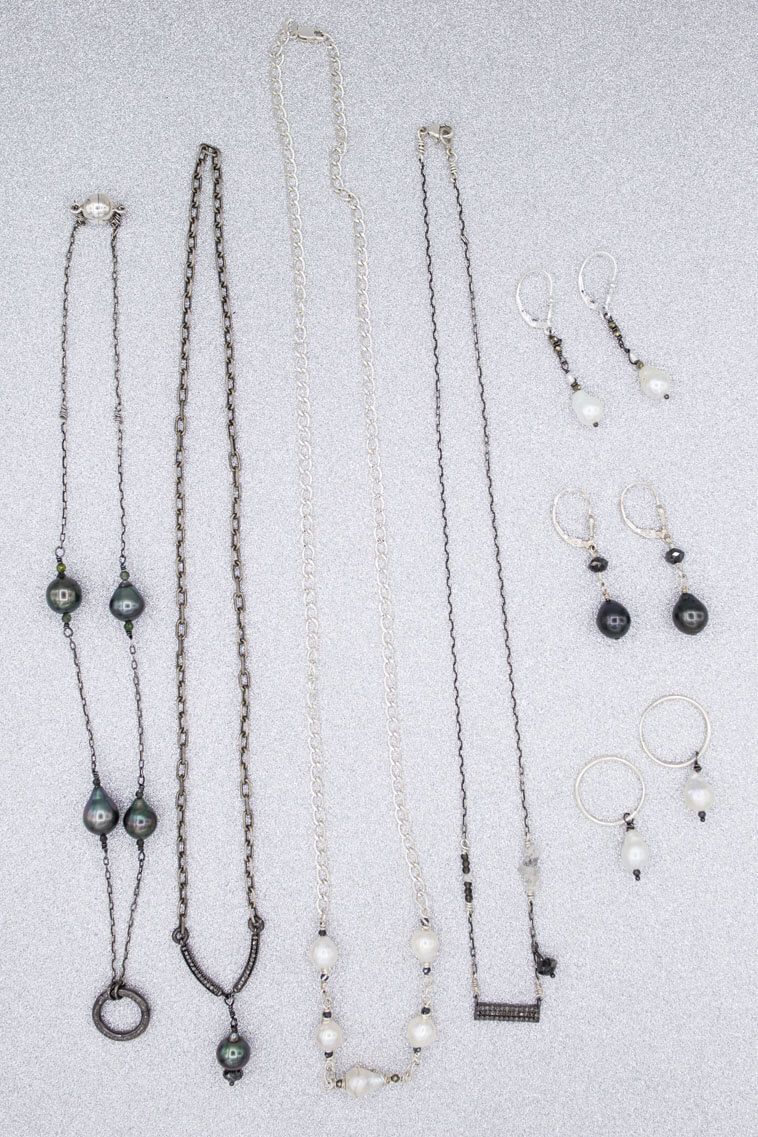 A bunch of necklaces and earrings on a white surface