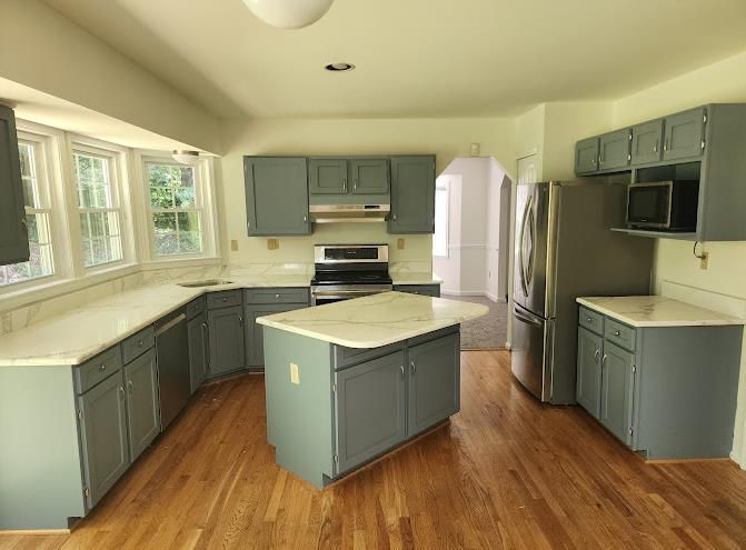 A kitchen under construction with white cabinets and a dishwasher.