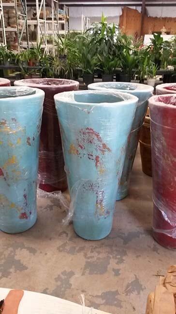 A bunch of pots are sitting on the ground in a warehouse.