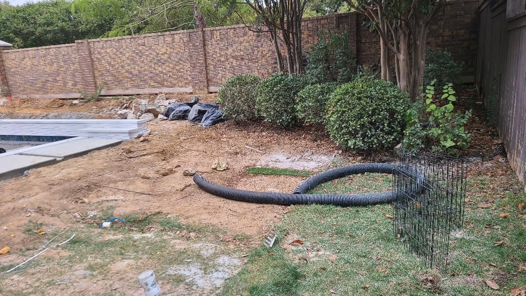 A hose is laying in the grass next to a pool.