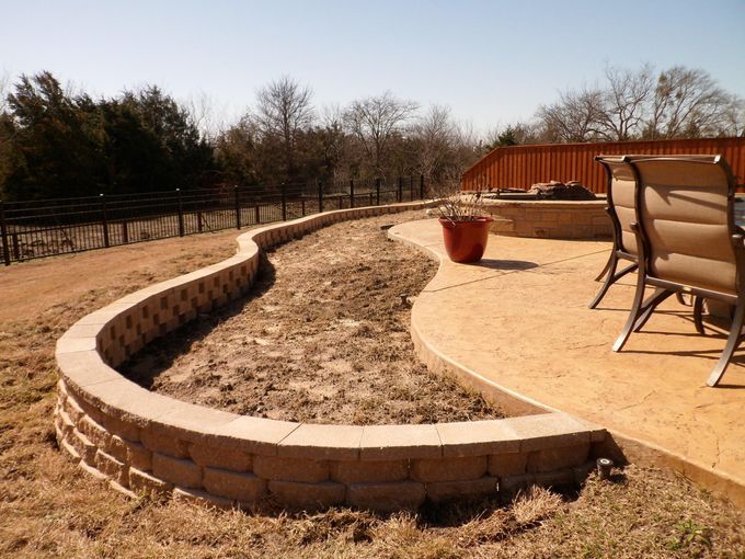 A patio with chairs and a brick wall