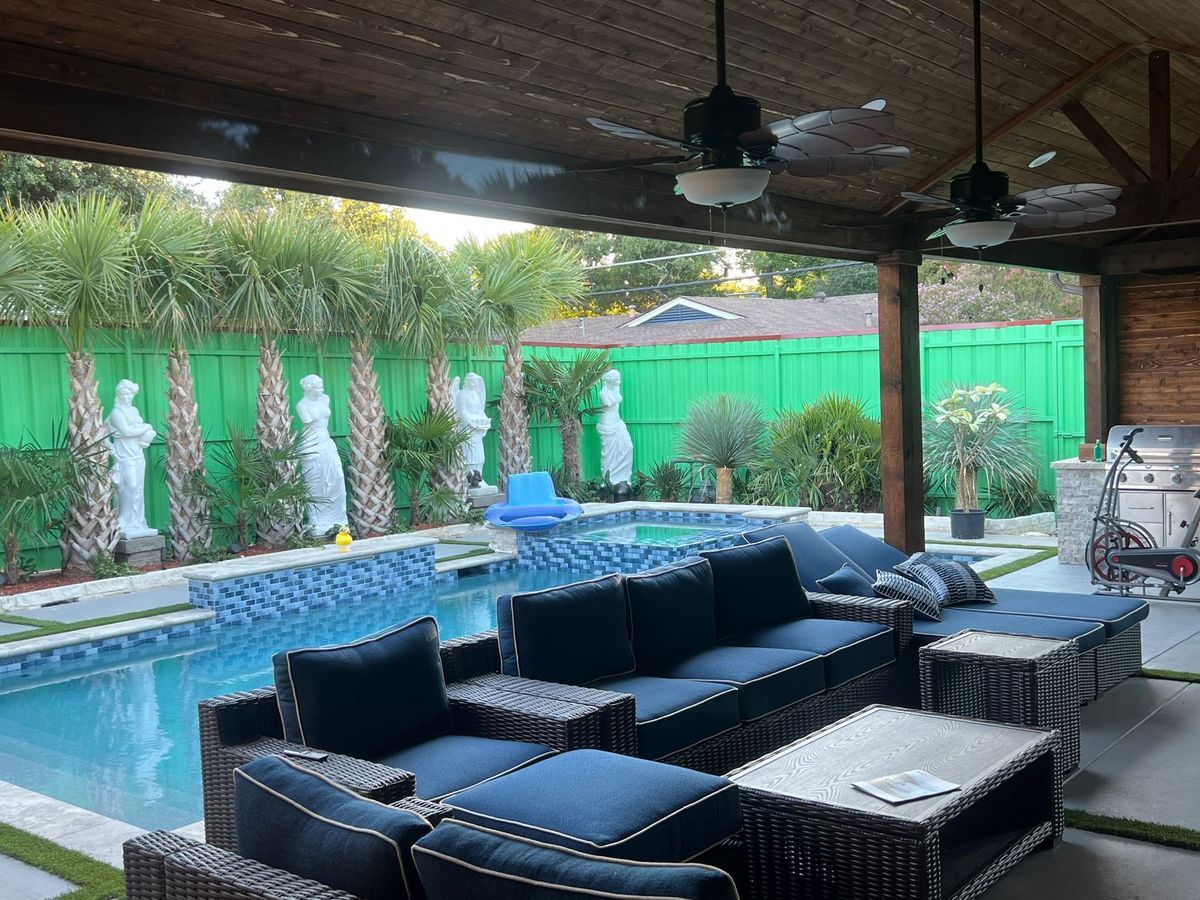 A patio area with furniture and a swimming pool in the background.