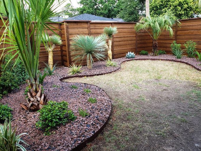A garden with a wooden fence and lots of plants