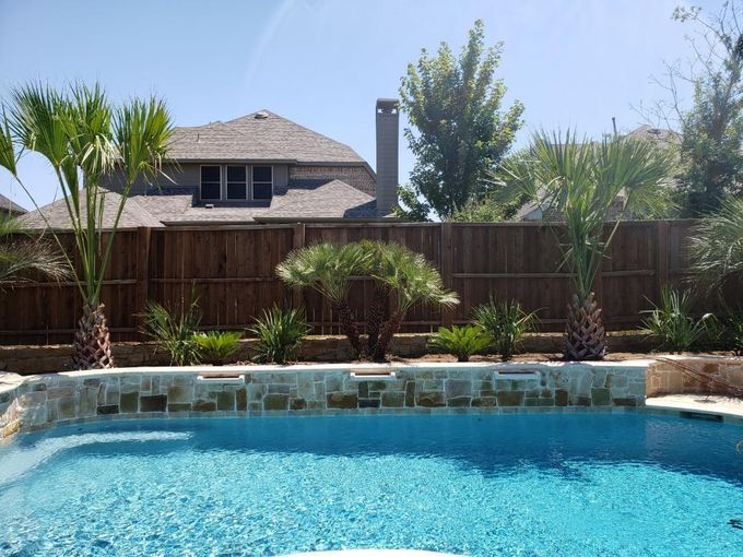 A large swimming pool with a wooden fence surrounding it