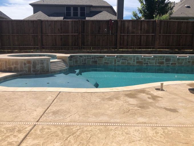 A large swimming pool with a wooden fence surrounding it.