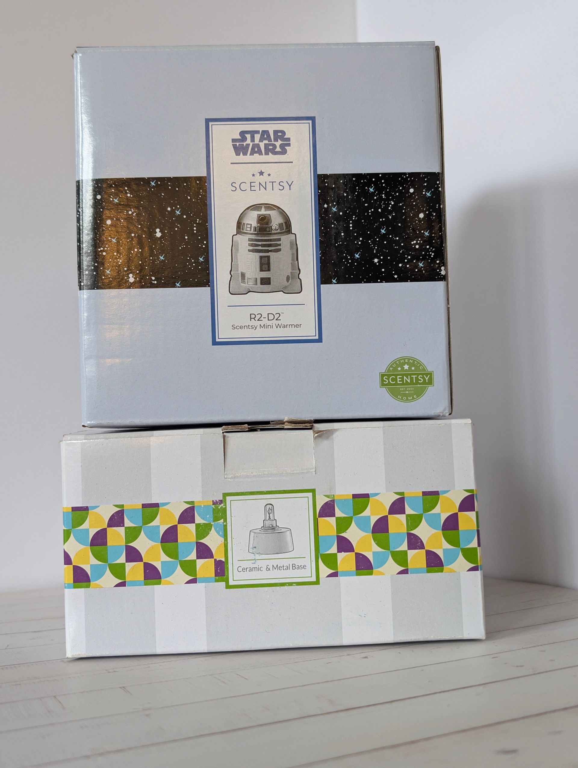 Twee ingepakte dozen, waarvan één met een Star Wars-thema, op elkaar gestapeld op een witte ondergrond. R2-D2  Disney