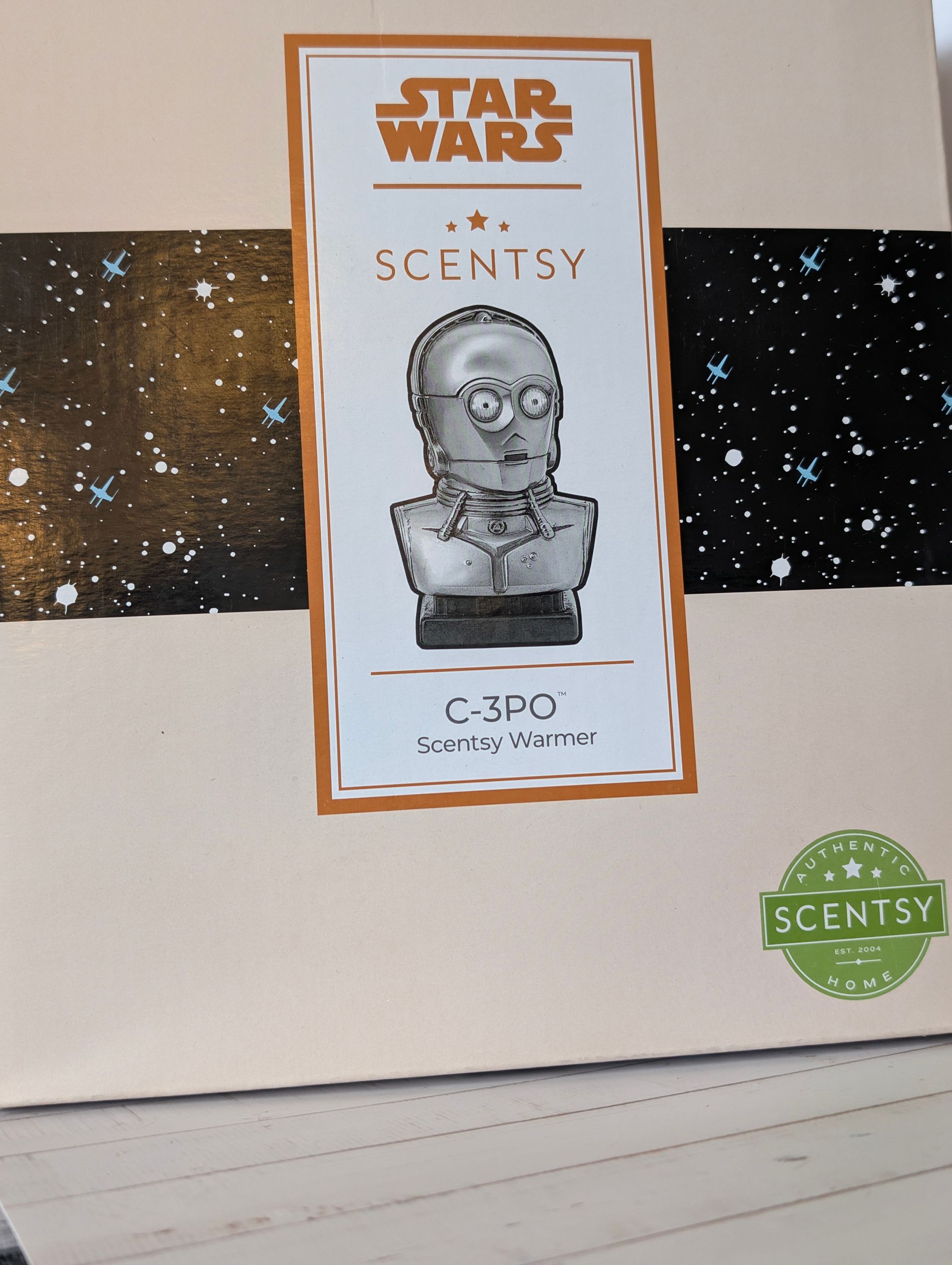 Scentsy waxbranderdoos met C-3PO-afbeelding, sterrenhemelachtergrond, lichtbruin, wit en bruin. Met Star Wars-logo.