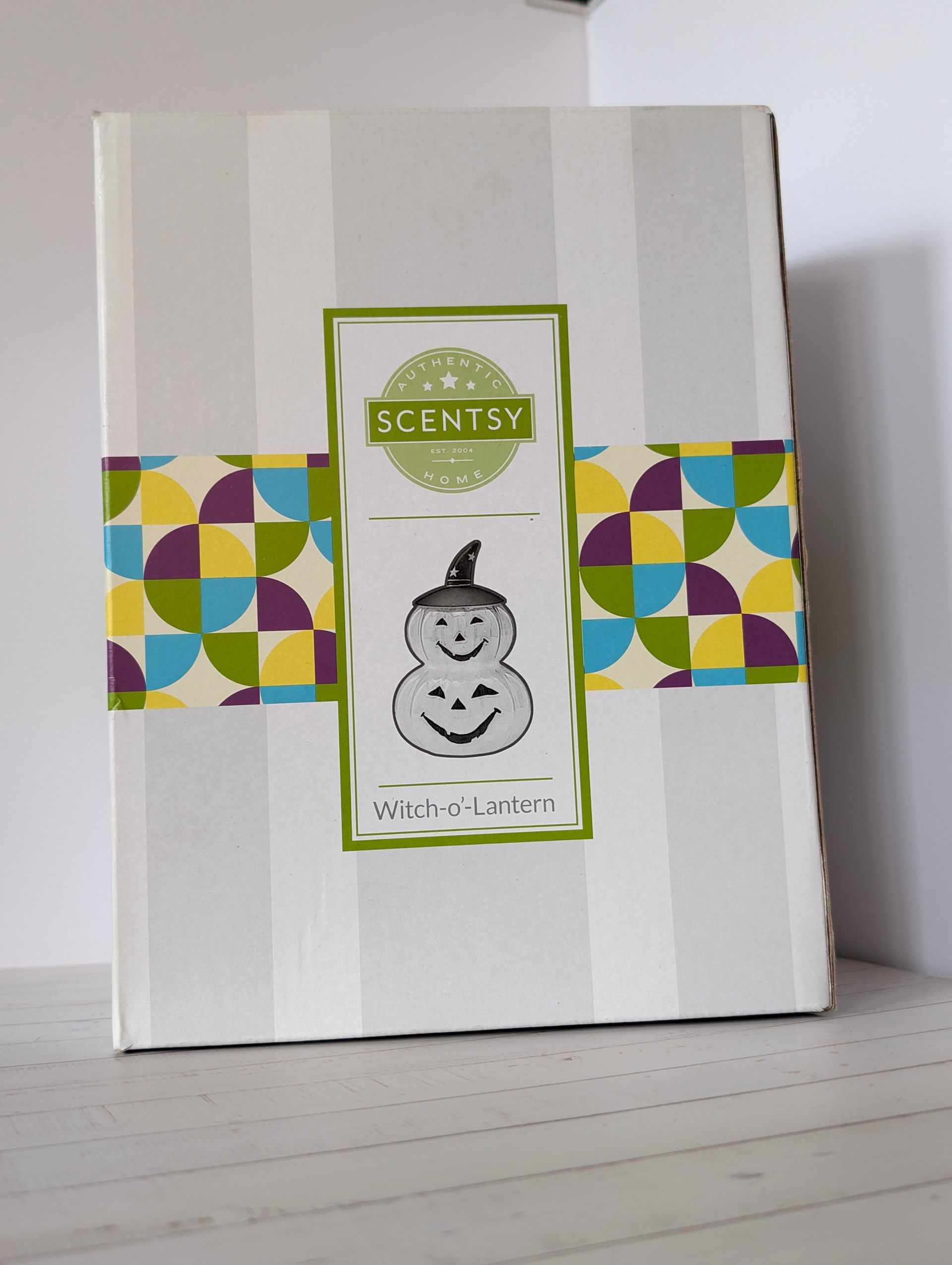 Scentsy-doos met Halloween-design, grijze strepen en een kleurrijk patroon. Scentsy Witch-'o-Lantern

