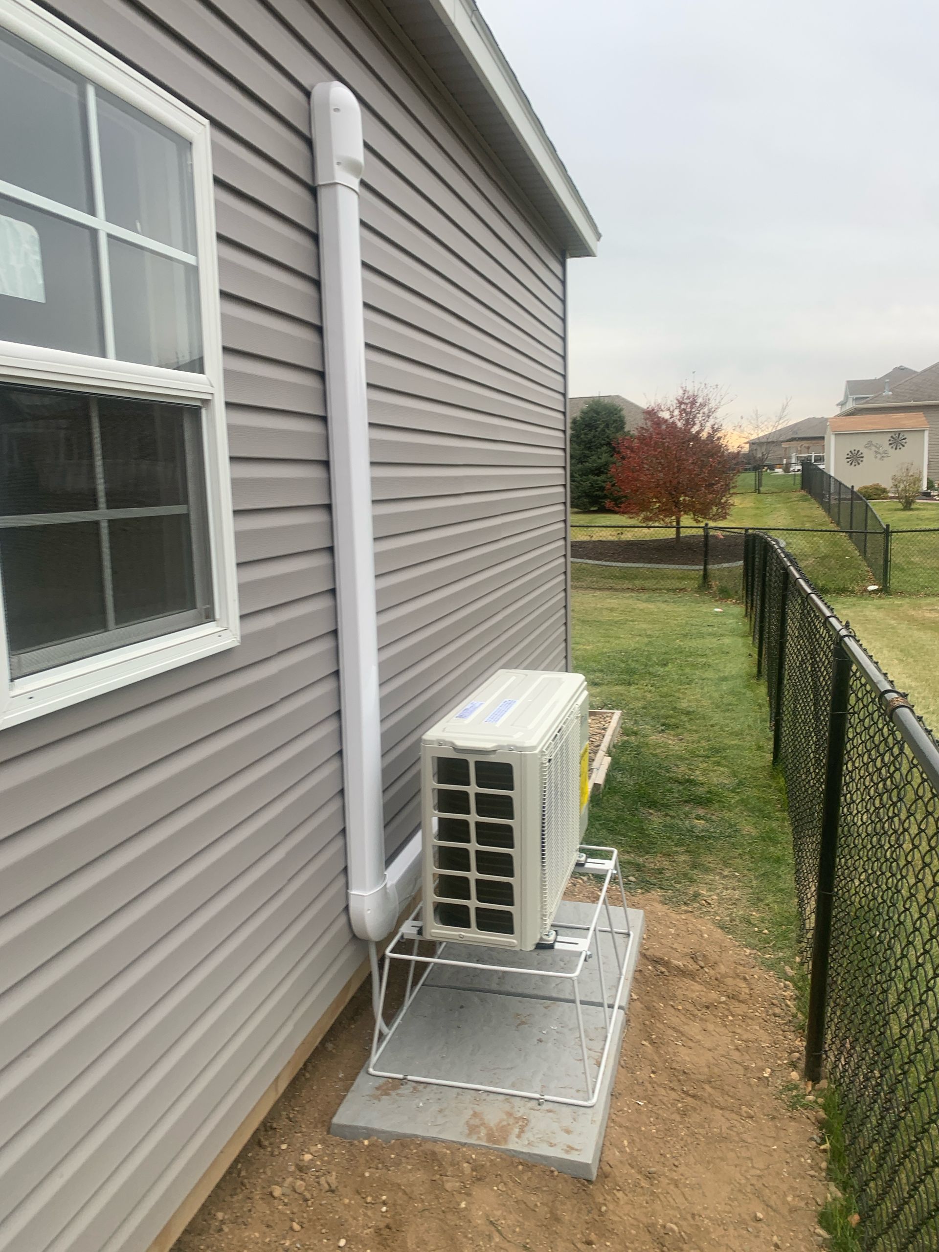 HVAC technician repairs outdoor unit on a building with a blue sky background.