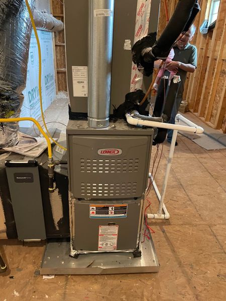 A new furnace being installed inside a wooden framed room.