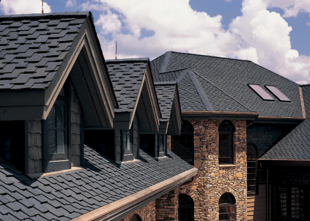Close-up of asphalt shingles in various colors: blue, gray, brown, and red-brown.