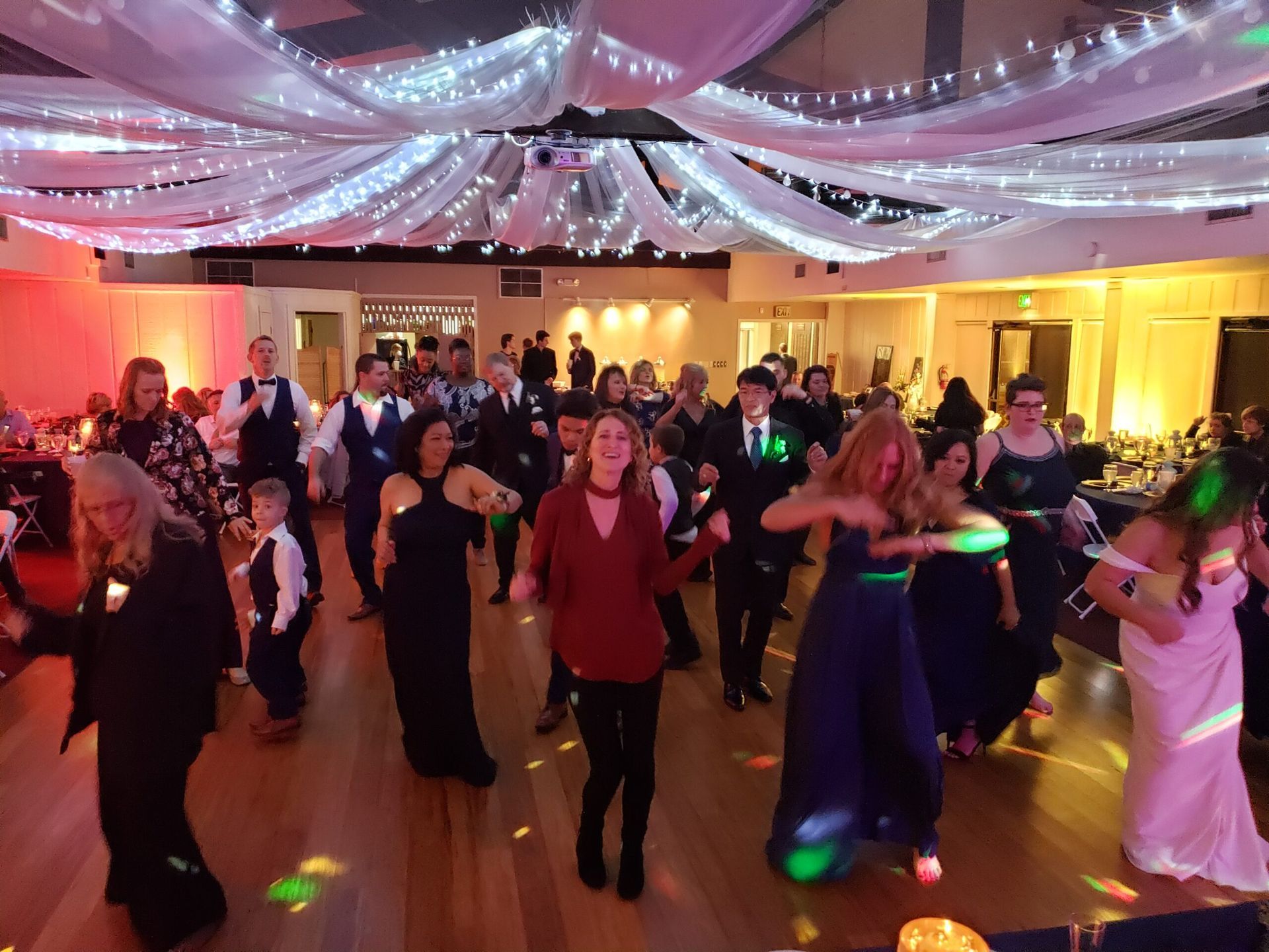 A large group of people are dancing in a large room.