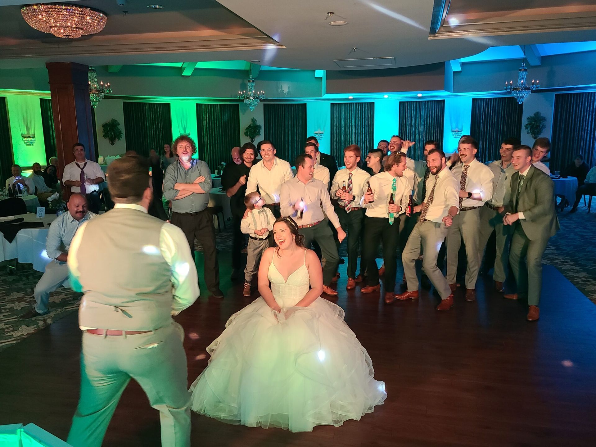 A group of people are standing around a bride in a wedding dress.