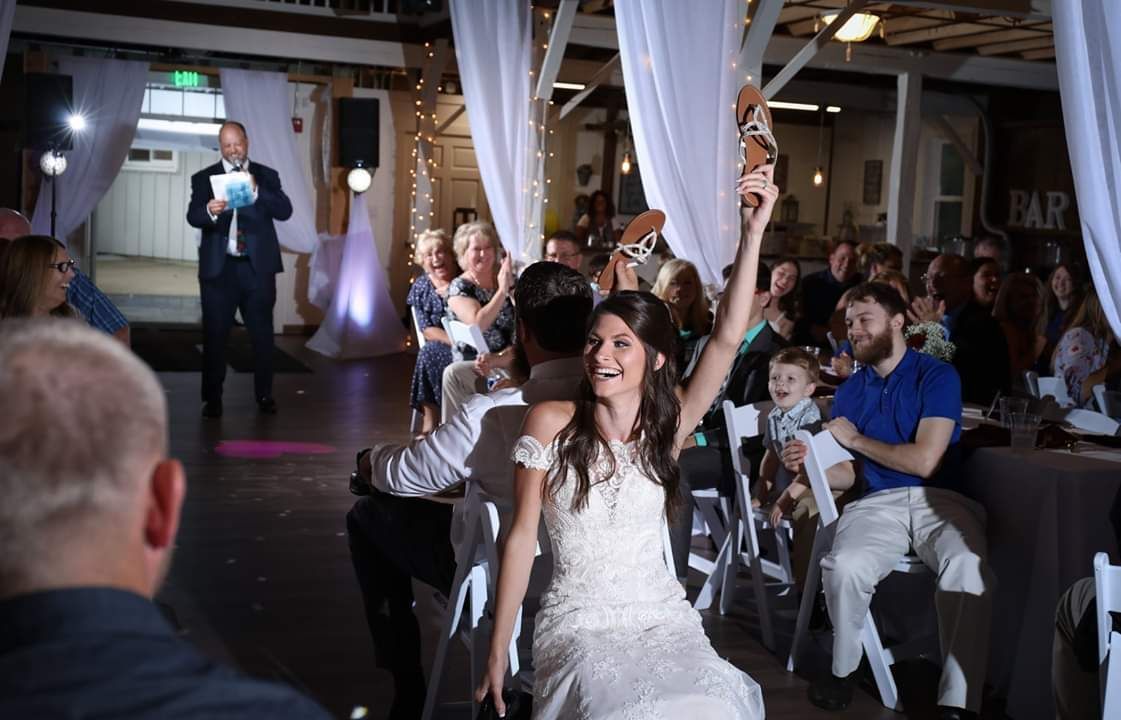 A bride and groom are dancing in front of a crowd at a wedding reception.