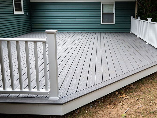 New composite deck on the back of a house with green vinyl siding